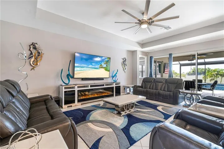 Spacious living area featuring a large television console with an integrated electric fireplace