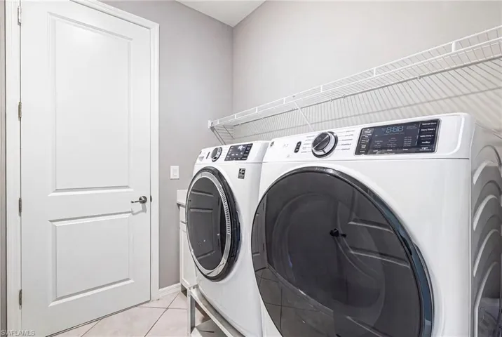 Dedicated laundry area featuring a white two-panel door, wire shelving, light gray wall paint, and diagonal tile flooring