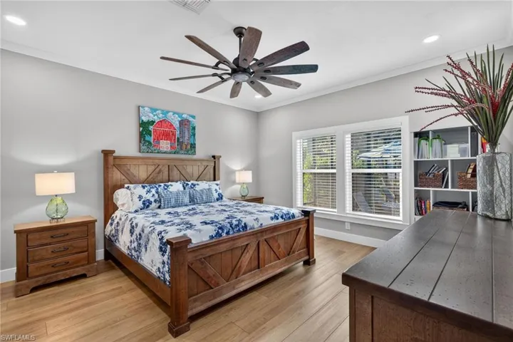 Bedroom with light wood finished floors, recessed lighting, ornamental molding, and a ceiling fan
