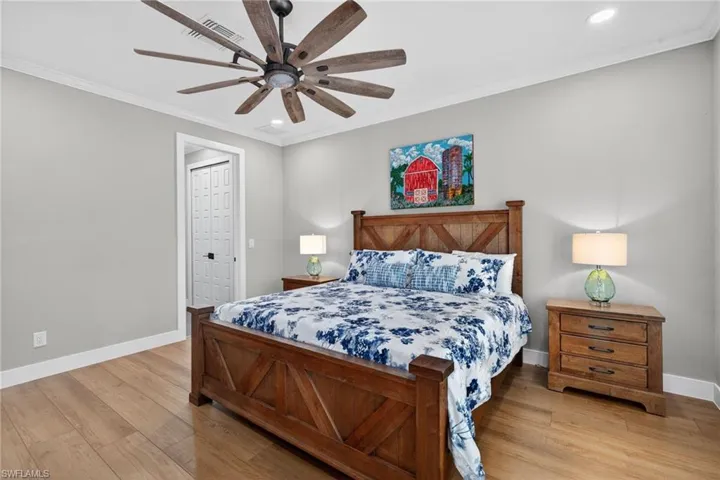 Bedroom with light wood-style flooring, crown molding, recessed lighting, and a ceiling fan