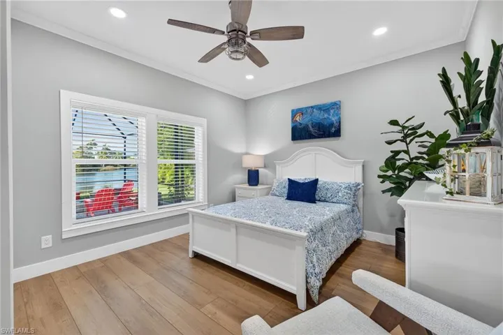 Bedroom featuring light wood-type flooring, a ceiling fan, ornamental molding, and recessed lighting