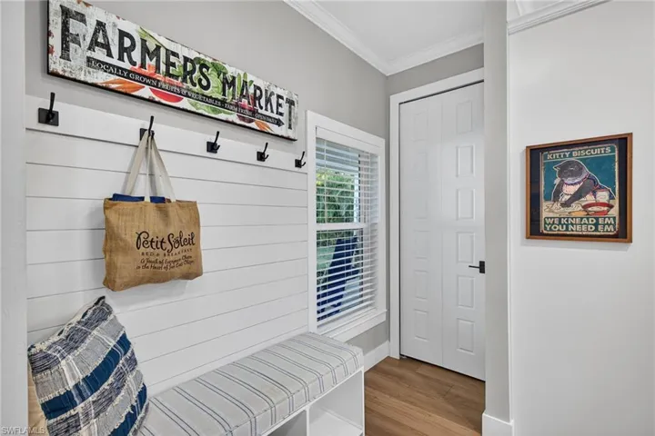 Mudroom featuring ornamental molding and light wood-style flooring