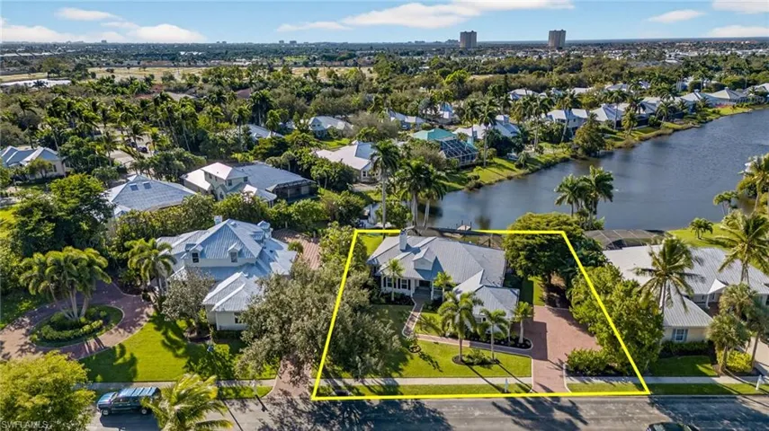 Aerial view of residential area with property parcel outlined and a large body of water