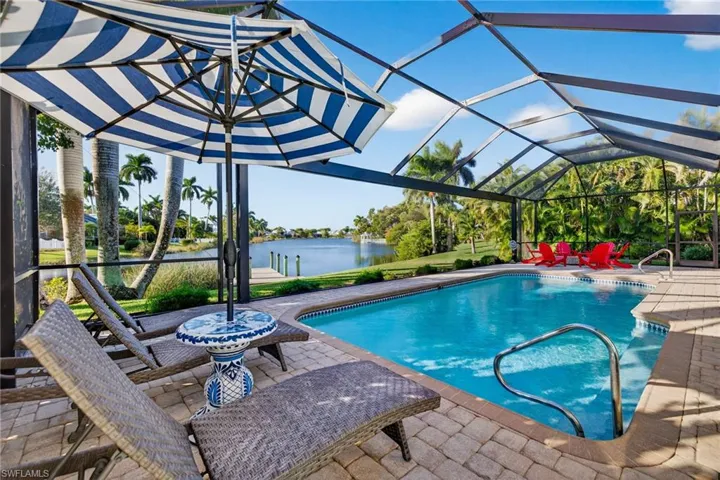 Outdoor pool featuring a lanai, a patio, and a water view