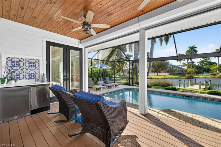 Outdoor pool featuring a lanai, french doors, and a deck with water view