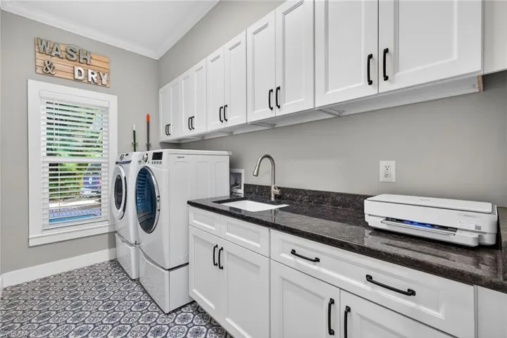 Washroom with ornamental molding, washer and clothes dryer, and cabinet space