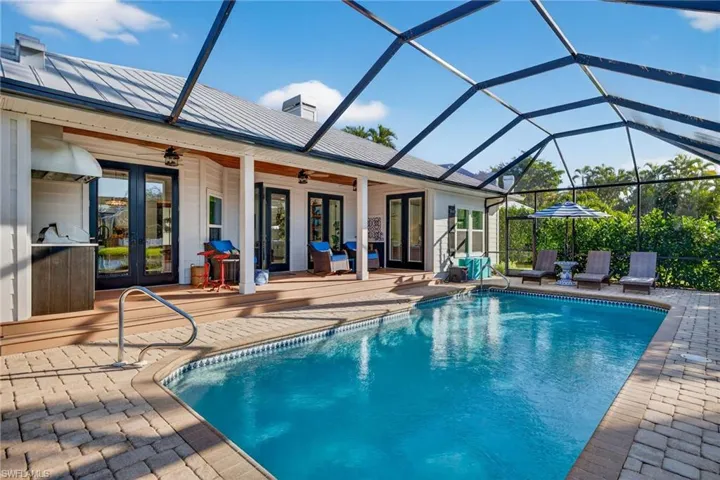 Swimming pool featuring french doors, a lanai, a patio, and a grill