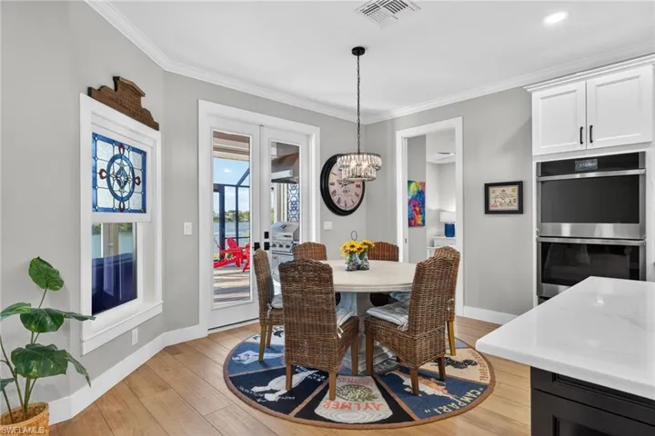 Dining area featuring a chandelier, light wood finished floors, and crown molding