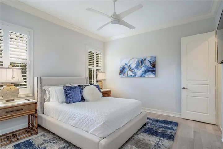 Bedroom with ceiling fan, crown molding, and light hardwood / wood-style flooring