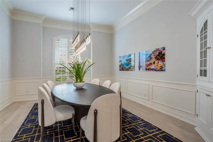 Dining area with light wood-type flooring and crown molding