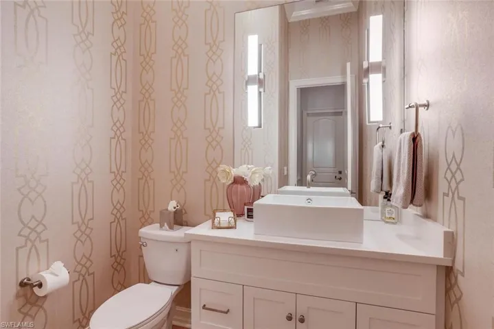 Bathroom featuring vanity, toilet, and a healthy amount of sunlight