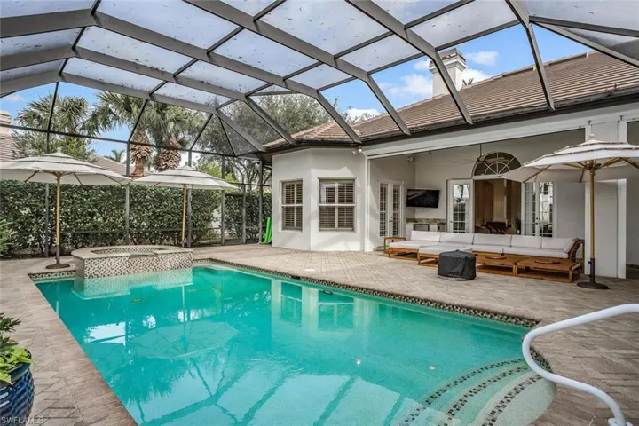 View of pool featuring an outdoor living space, a patio area, a lanai, and an in ground hot tub