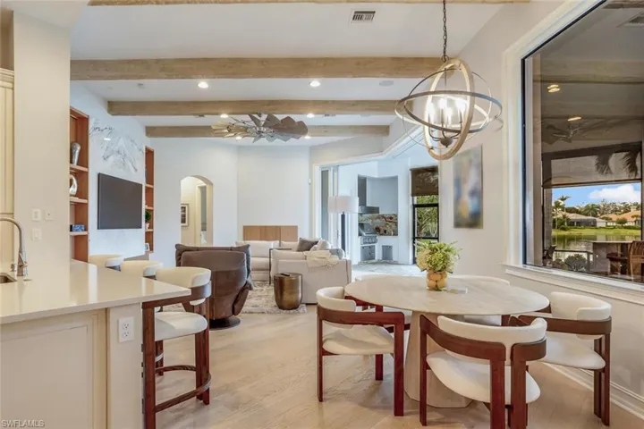 Dining space featuring beamed ceiling, light hardwood / wood-style floors, and a notable chandelier