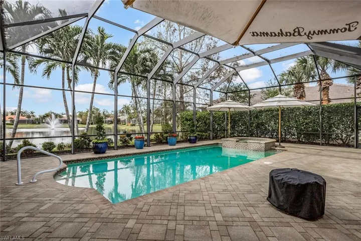 View of pool featuring a grill, a lanai, an in ground hot tub, and a patio area
