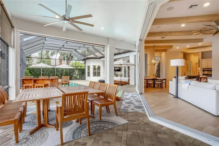 Sunroom / solarium with ceiling fan and lofted ceiling with beams