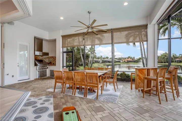 Sunroom featuring ceiling fan and a water view