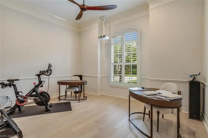 Home office featuring crown molding, light hardwood / wood-style flooring, and ceiling fan