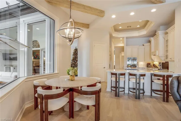 Dining space with a notable chandelier and light wood-type flooring