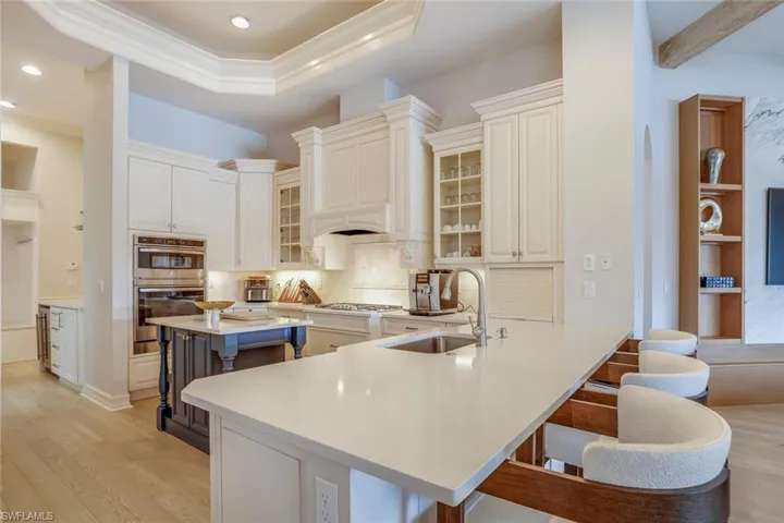 Kitchen featuring sink, kitchen peninsula, light hardwood / wood-style floors, a kitchen bar, and appliances with stainless steel finishes