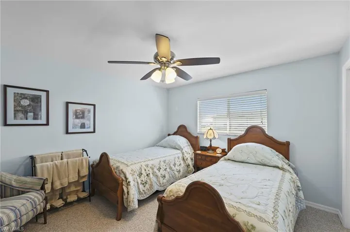 Carpeted bedroom with a ceiling fan