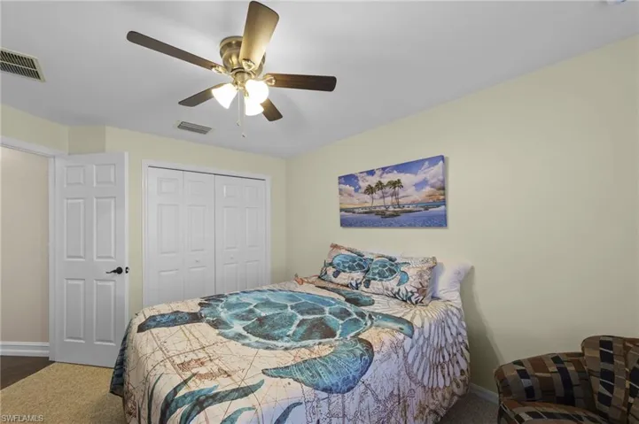 Bedroom featuring ceiling fan, a closet, and dark colored carpet