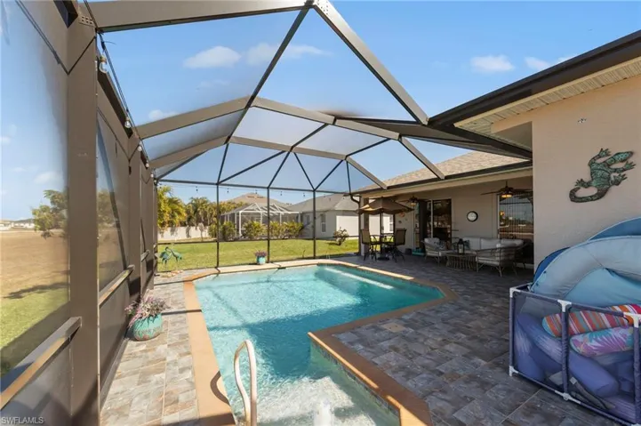 Swimming pool featuring a patio, outdoor lounge area, a sunroom, a lawn, and glass enclosure