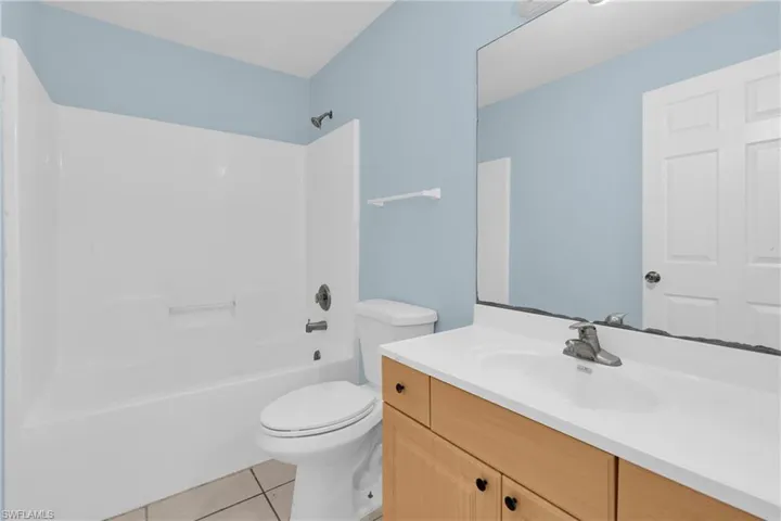 Bathroom featuring vanity, light tile patterned flooring, and shower / bathtub combination