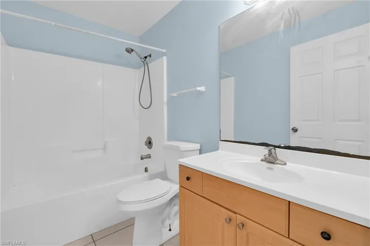 Bathroom featuring vanity,  shower combination, and light tile patterned floors