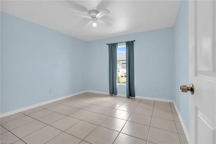 Spare room featuring a ceiling fan and light tile patterned floors