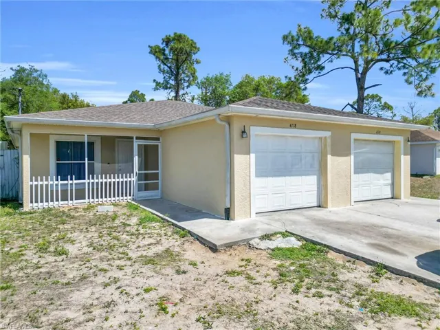Ranch-style home with stucco siding, a garage, a shingled roof, a sunroom, and driveway