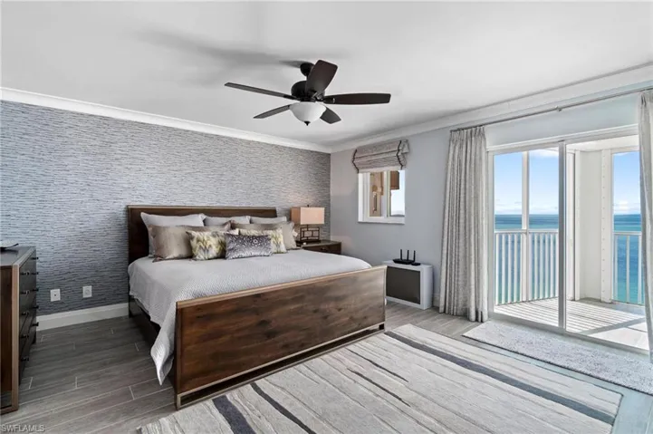 Bedroom featuring ornamental molding, access to exterior, wood finished floors, ceiling fan, and wallpapered walls