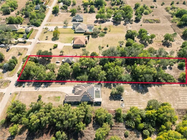 Aerial view of sparsely populated area featuring property parcel outlined