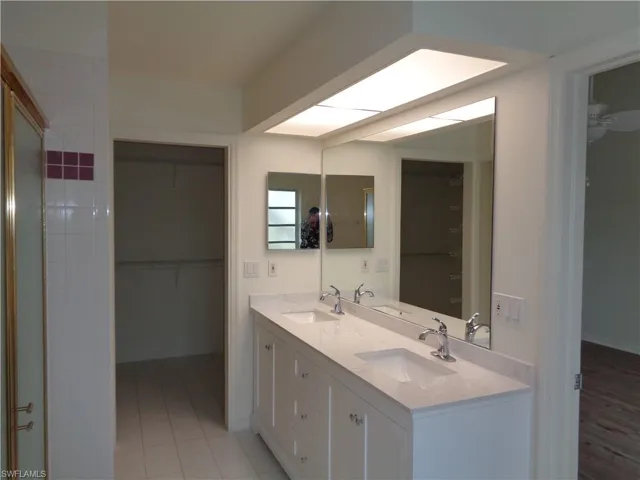 Bathroom featuring a walk in closet and double vanity