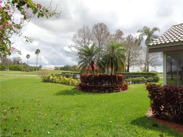 View of green lawn with a sunroom