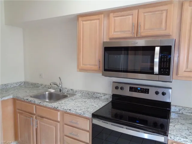 Kitchen featuring appliances with stainless steel finishes and light brown cabinetry