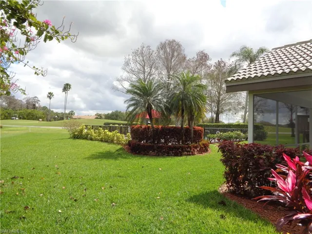 View of grassy yard featuring a sunroom