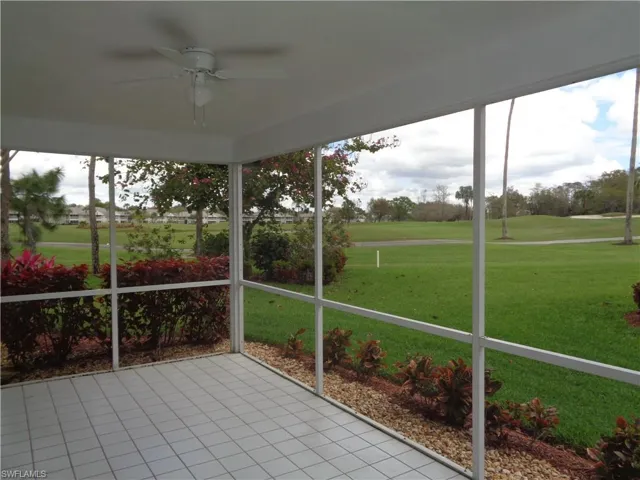 Unfurnished sunroom with ceiling fan, golf course view, and plenty of natural light
