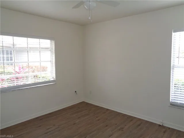 Empty room featuring dark wood-style flooring and ceiling fan