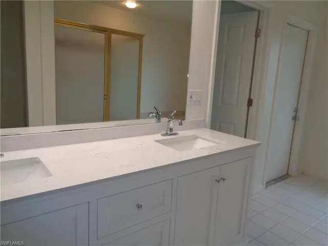 Bathroom featuring double vanity and light tile patterned floors