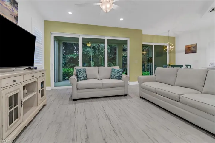 Living room with light wood tile flooring and ceiling fan