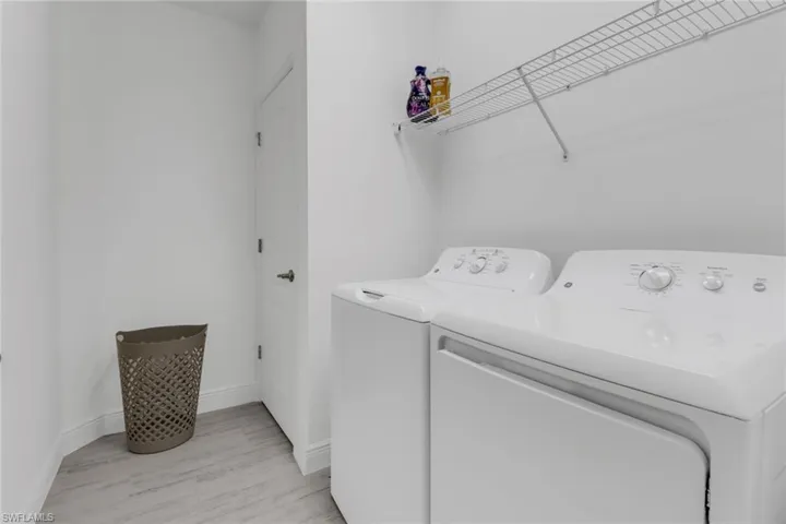 Laundry room with washer and dryer and light hardwood type tile
