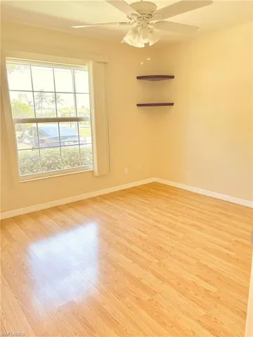 Guest room with ceiling fan, a healthy amount of sunlight, and light hardwood / wood-style flooring