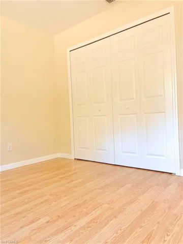 Unfurnished bedroom featuring light wood-type flooring and a closet