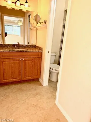 Bathroom featuring tile patterned flooring, vanity, and toilet