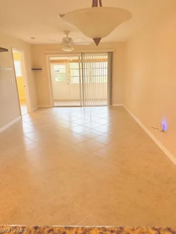 Unfurnished room featuring ceiling fan, light tile patterned flooring, and a healthy amount of sunlight