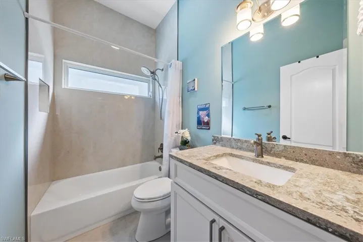 Full bathroom with vanity, tile patterned flooring, bathing tub / shower combination, and toilet