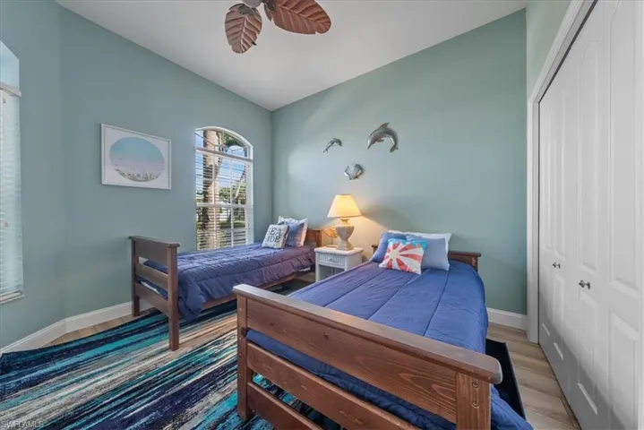 Bedroom featuring lofted ceiling, light hardwood / wood-style flooring, ceiling fan, and a closet