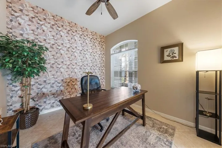Office with vaulted ceiling, ceiling fan, and light tile patterned flooring