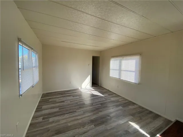 Empty room featuring dark wood-type flooring