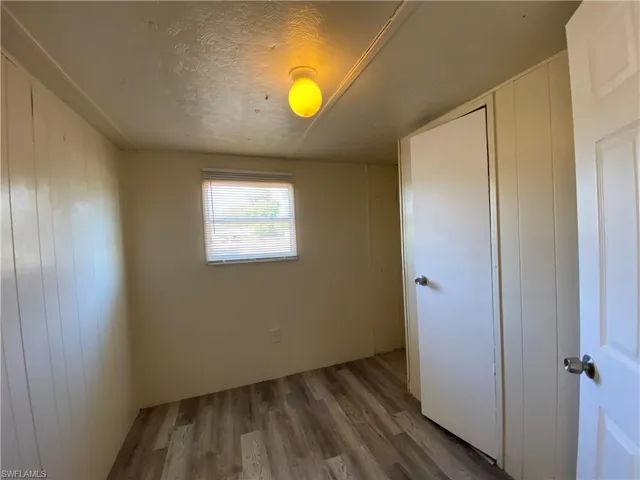 Unfurnished bedroom with wood finished floors and a textured ceiling